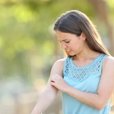 woman outside annoyed by mosquitoes